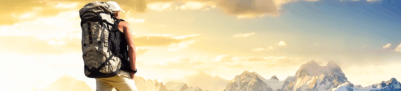 A man is standing on top of a mountain with a backpack.